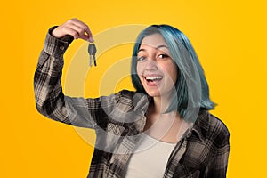 Smiling young woman student with blue hair holding keys
