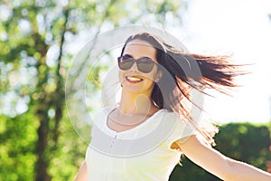 Smiling young woman with sunglasses in park
