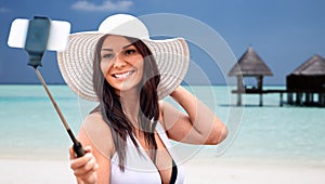 Smiling young woman taking selfie with smartphone