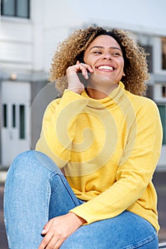 Smiling young woman talking on mobile phone in city