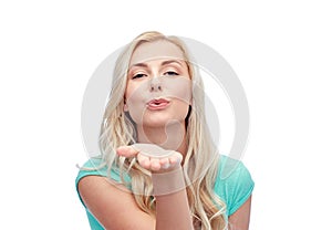 Smiling young woman or teen girl sending blow kiss