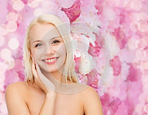 Smiling young woman touching her face skin