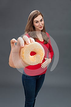 Smiling young woman touching her hungry stomach for junk food