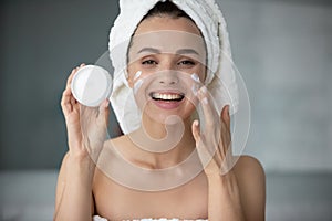 Smiling young female recommend moisturizing facial cream