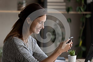 Smiling young woman use smartphone gadget browsing internet