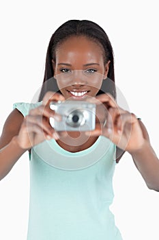 Smiling young woman using her digi cam photo
