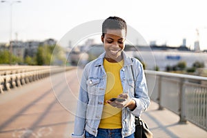 Smiling young woman using smartphone outdoors