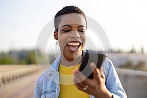 Smiling young woman using smartphone outdoors