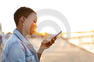 Smiling young woman using smartphone outdoors