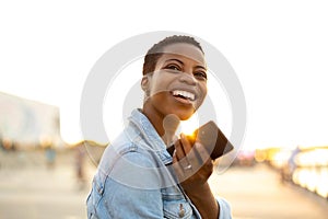 Smiling young woman using smartphone outdoors