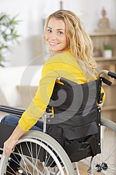 smiling young woman in wheelchair looking at camera