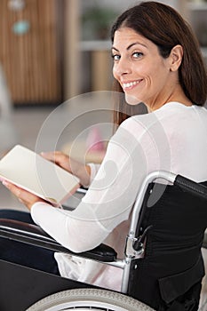 smiling young woman in wheelchair looking at camera