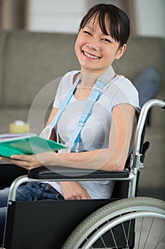 smiling young woman in wheelchair looking at camera