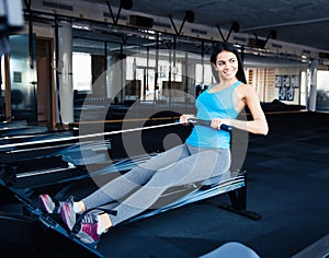 Smiling young woman working out on simulator