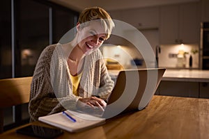 Smiling Young Woman Working Or Studying On Laptop At Home At Night