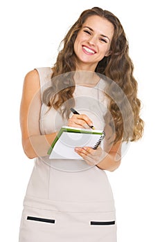 Smiling young woman writing in notepad