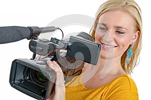 smiling young woman in yellow t-shirt with professional camcorder, on white