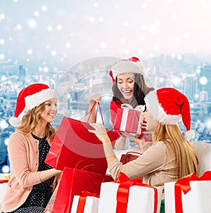 Smiling young women in santa hats with gifts