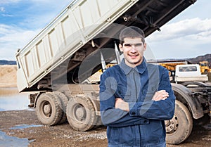 Smiling young worker and tip truck