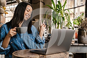 Smiling yuong african woman working on laptop