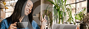 Smiling yuong african woman working on laptop