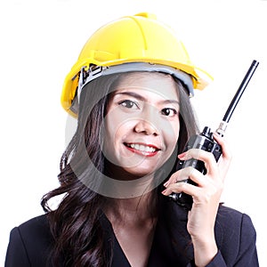 Smilling female construction worker talking with a walkie talkie