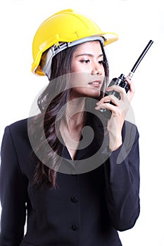 Smilling female construction worker talking with a walkie talkie