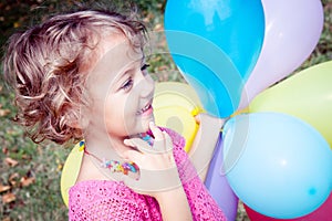 smilling girl with colorful balloons