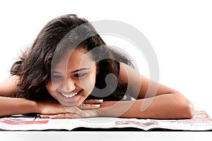 Smilling indian teen reading newspaper