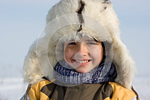 Smilling little boy in the fur-cap