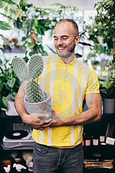 Smilling man with cactus in florist shop