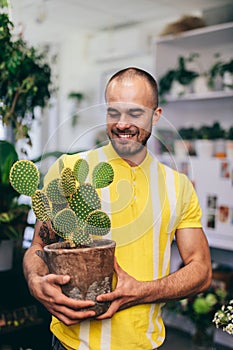 Smilling man with cactus in florist shop