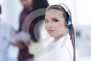 Smilling young business woman in front of her team.