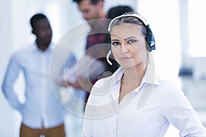 Smilling young business woman in front of her team.