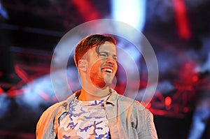 Smilling Young Man under Colorful Spotlights, Fame