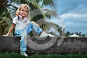 Smily caucasian kid girl with headphones looking in camera.