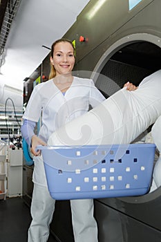 Smily woman working at industrial laundry