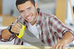 smily young workman using handsaw