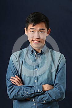 Smirking young Asian man with crossed hands