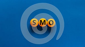 SMO, social media optimization symbol. Concept word SMO - social media optimization on yellow tennis table on beautiful blue