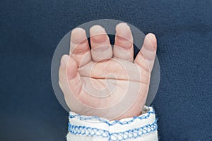 Smof newborn baby. Infant fingers and palm.  Little baby hand on blue backgroundall hand