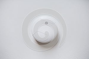 Smoke alarm, sensor or detector on white ceiling