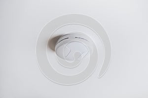 Smoke alarm, sensor or detector on white ceiling