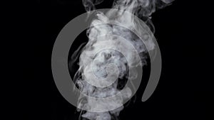 Smoke billowing over steady flow on black background, slow motion