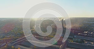 Smoke from the chimney of a factory at sunset aerial view. Metallurgical plant at sunrise top view. Industrial zone