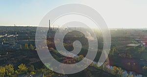 Smoke from the chimney of a factory at sunset aerial view. Metallurgical plant at sunrise top view. Industrial zone