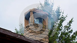 smoke from the chimney. A residential building in the suburbs on a cloudy day in a cold winter pollutes the air with