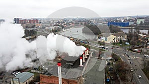 Smoke from chimneys forms clouds. Large clouds over the city from pipes of thermal power plant.  Smokestack pipes shooted with