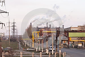 smoke chimneys on a large industrial complex. high-voltage power lines, and production workshops.