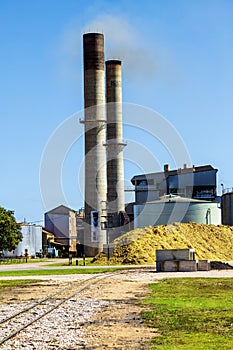 Smoke billowing from chimney stack of sugar mill NorthQueensland Australia photo
